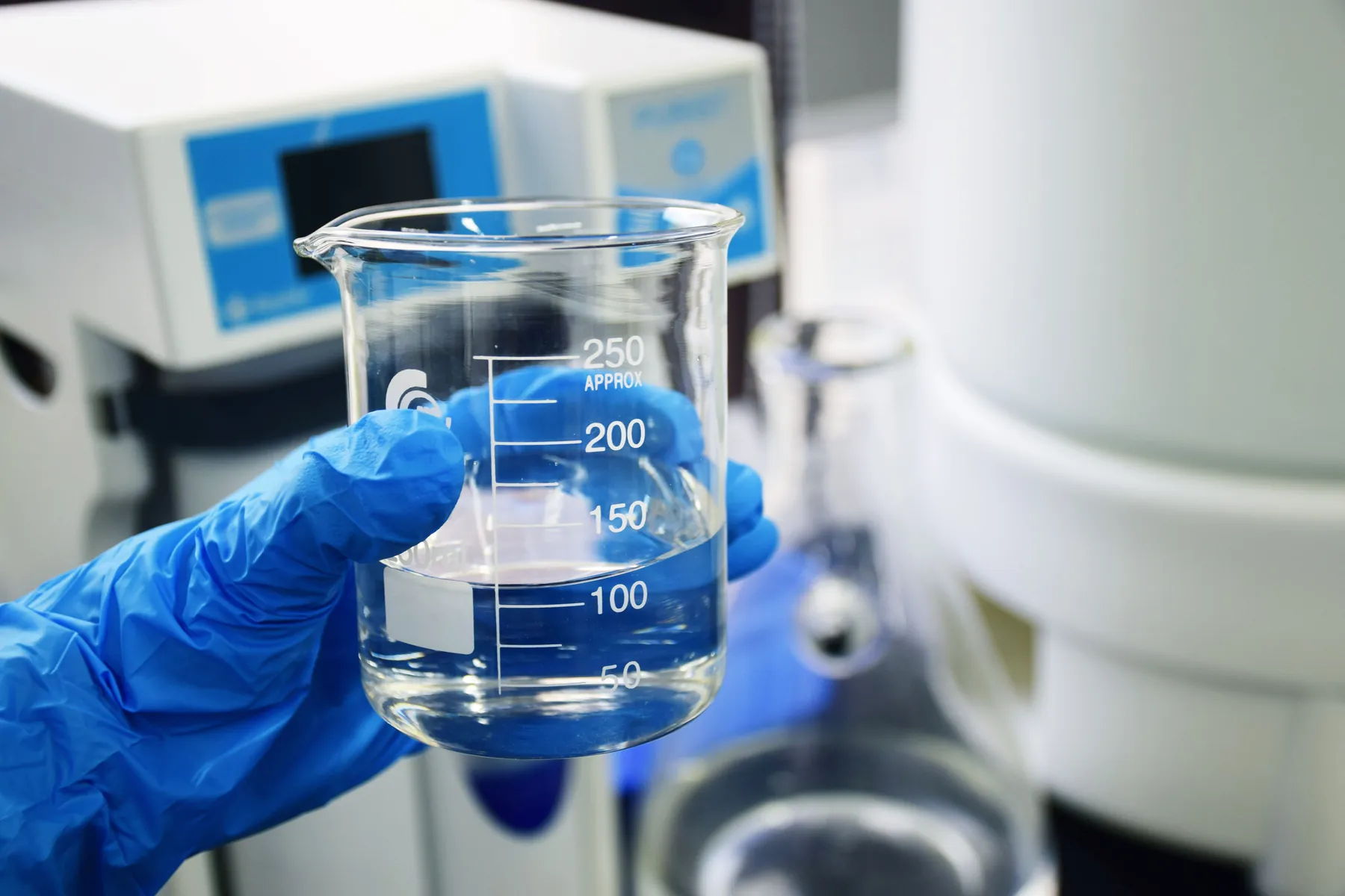 Analista sosteniendo un vaso de precipitados con una muestra de agua