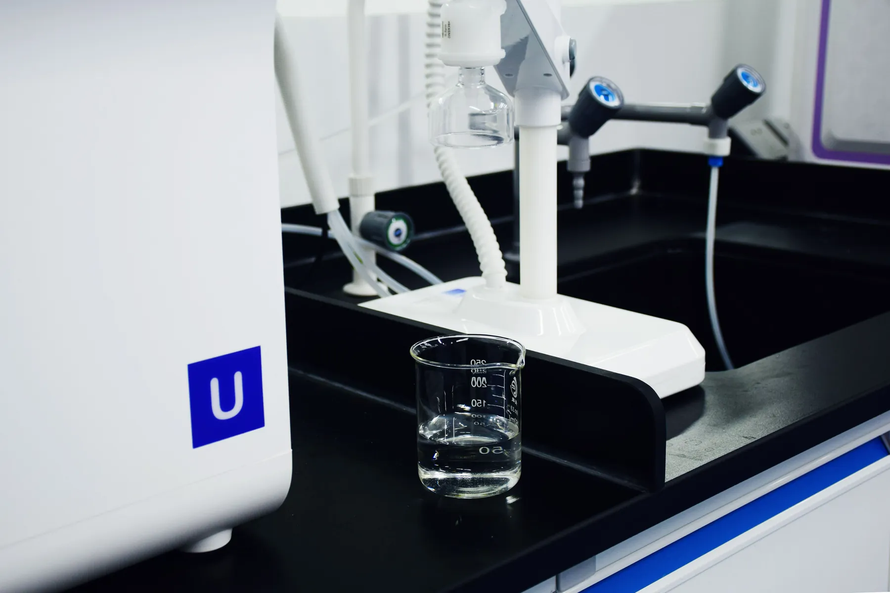Sistema de purificación de agua de laboratorio dosificando en un vaso de precipitados