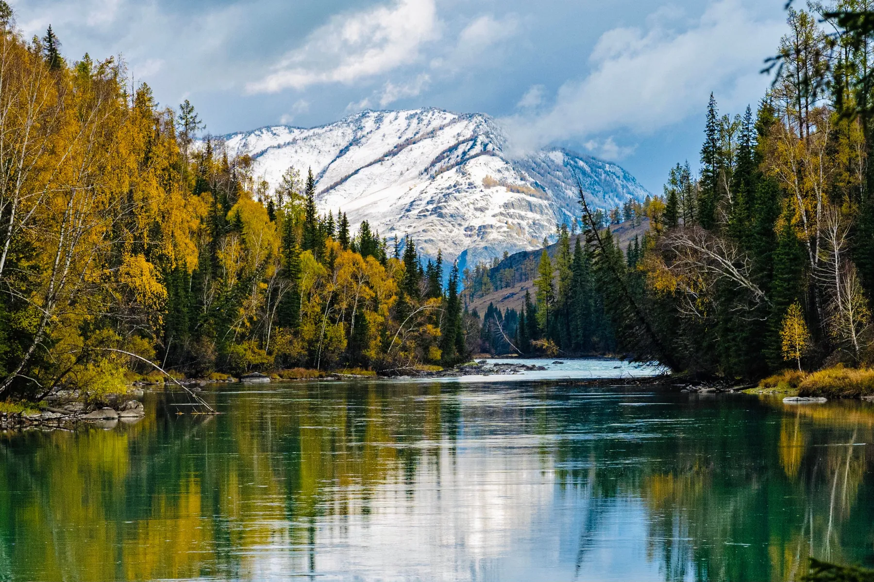 Río de montaña al pie de una cumbre nevada