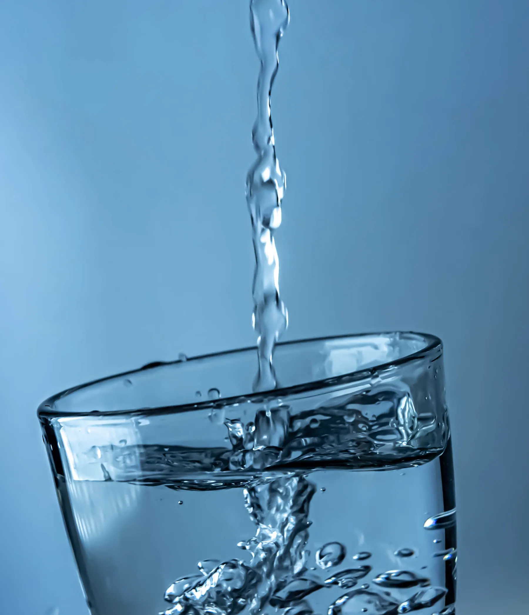 Chorro de agua purificada llenando un vaso de vidrio